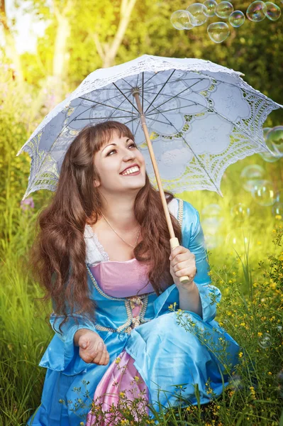 Laughing woman in medieval dress with bubble blowers — Stock Photo, Image