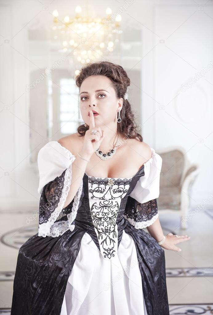 Young beautiful medieval woman in dress making silence gesture