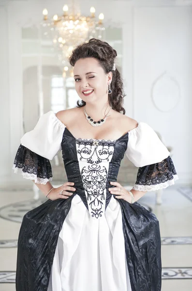Mooie jonge vrouw in lang middeleeuwse jurk knipogend — Stockfoto