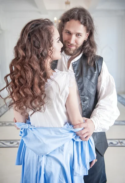 Bonito homem em traje medieval despir mulher bonita — Fotografia de Stock