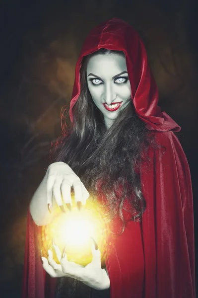 Halloween witch with fireball in her hands — Stock Photo, Image