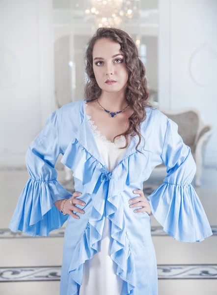 Beautiful young woman in blue dressing gown — Stock Photo, Image