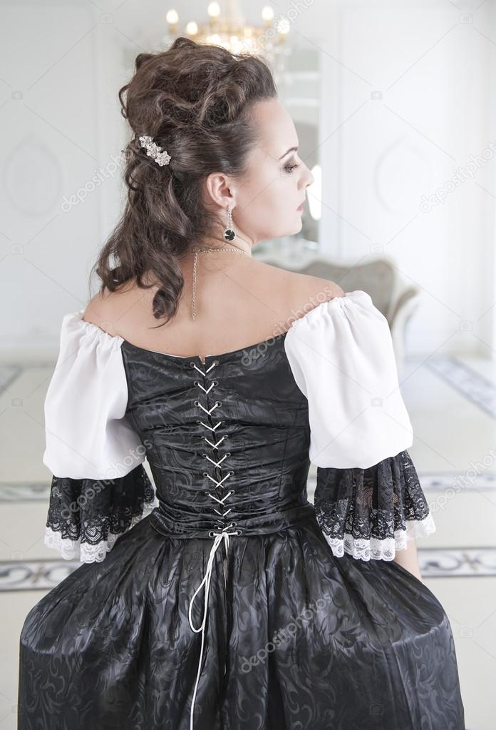 Beautiful medieval woman in black and white dress, back