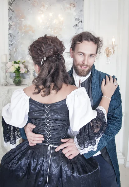 Hombre guapo desatando corsé de mujer en vestido medieval —  Fotos de Stock