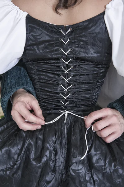 Άνθρωπος τα χέρια αποδέσμευση κορσέ γυναίκας στο μεσαιωνικό φόρεμα — Φωτογραφία Αρχείου