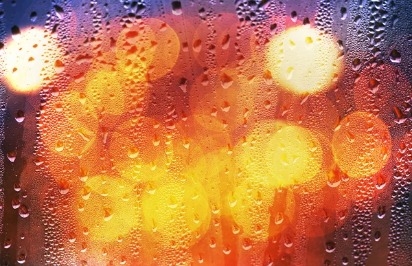 Drops of rain on glass with defocused lights — Stock Photo, Image