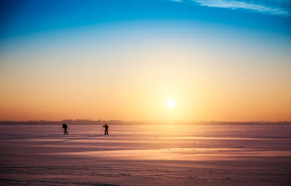 Beautiful winter sunset landscape with cross-country skiers — Stock Photo, Image