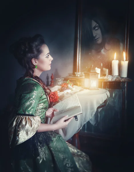 Donna con libro in abito retrò e fantasma allo specchio — Foto Stock