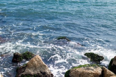 Okyanus dalgaları taşlara çarpıp çarpıyor. Turkuaz deniz suyu.