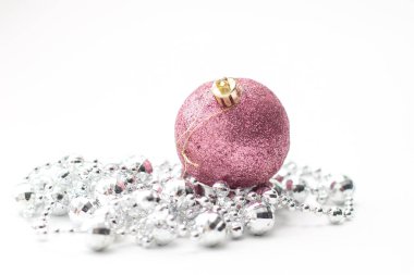 Noel pembe topu ve gümüş çelenk. Beyaz arkaplanda Noel süsleri