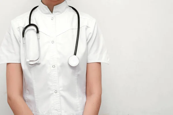 Beyaz bir ofiste doktor önlüğü giyen genç bir hemşire..