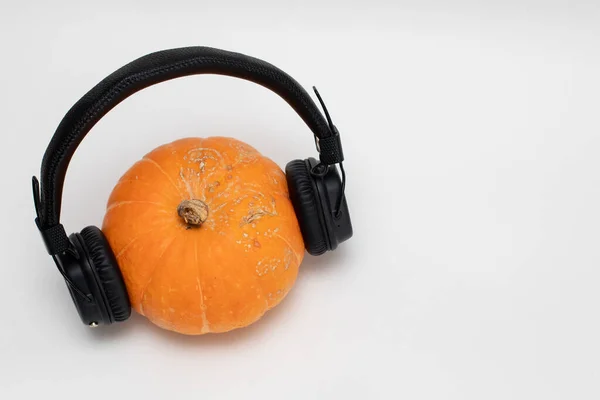Pomerančová dýně s černými sluchátky pro hudbu — Stock fotografie