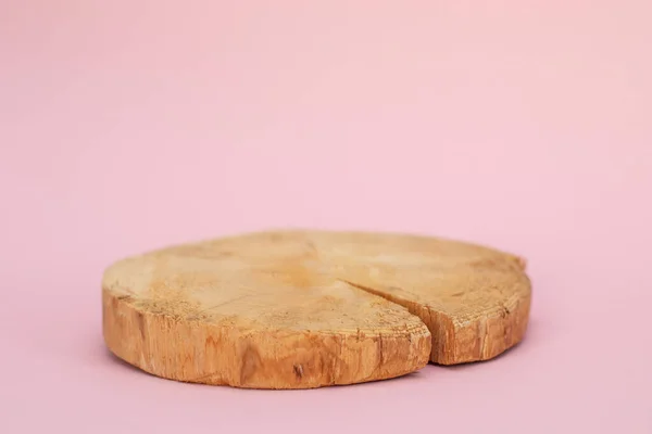 Wood slab texture. Large circular piece of wood cross section on pink background. Round piece of wood