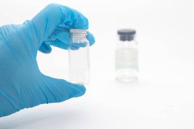 Doktor elinde aşıyla bir şişe tutuyor. İlaç ve uyuşturucu kavramı