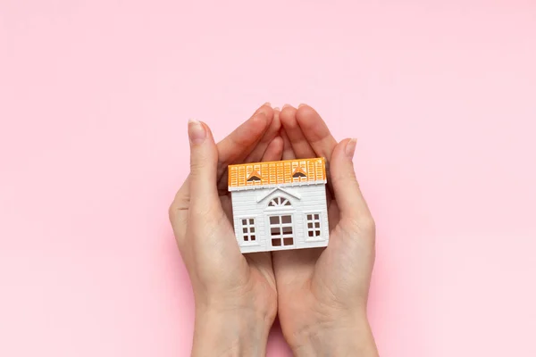 抵押贷款的概念是以房屋为基础的 手牵着玩具屋 女性手持房屋 — 图库照片