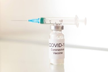 2019-nCoV COVID-19 virüsü için koronavirüs aşısı olan tüp ve cam zemin üzerinde şırınga