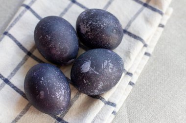Beyaz bir havluyla koyu mavi paskalya yumurtaları. Amberde boyanmış yumurtalar.