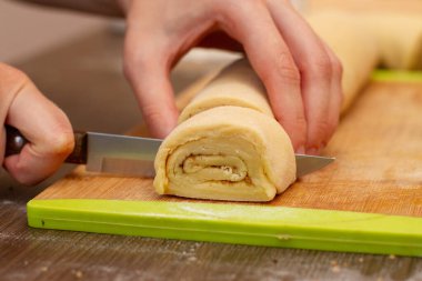 Kadın eli hamuru kesiyor. Hamur işi şefi hamuru keser. Çörek yapma süreci..