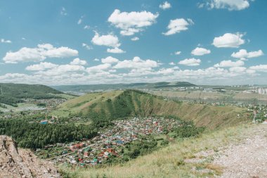 Orman manzarası ve açık bir günde dağ sırasından bulutlu gökyüzü. Taiga 'nın havadan görünüşü. Yeşil ormanı yukarıdan izle.