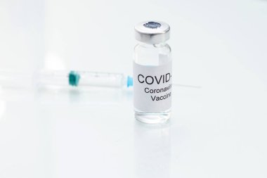 2019-nCoV COVID-19 virüsü için koronavirüs aşısı ve cam zemin üzerinde şırınga.