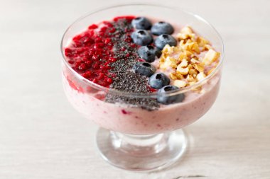 Taze böğürtlenli meyve suyu kasesi, yabanmersini, muz, ahududu ve fındık. Sağlıklı gıda konsepti