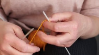 Turuncu iplikli atkı ören bir kadın. Ev yapımı..