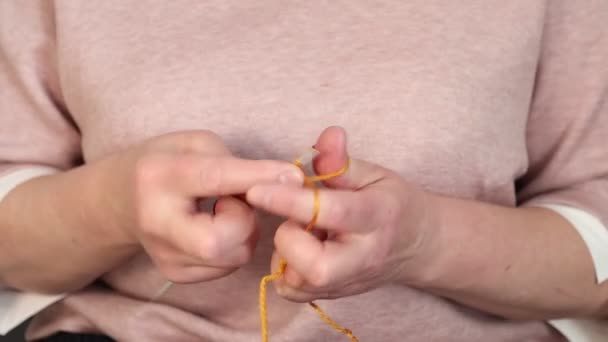 Frau macht Schlaufen auf Stricknadeln. Frau fängt an zu stricken. Hände nähen Garn mit Stricknadeln. — Stockvideo