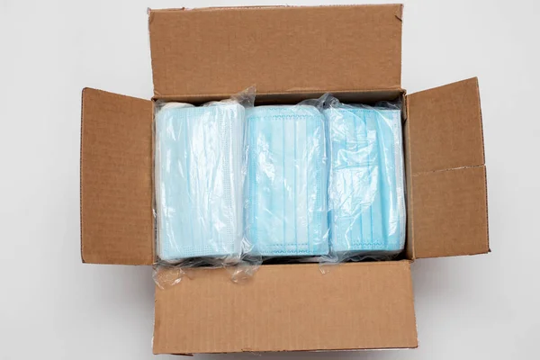Paketteki tek kullanımlık yüz maskeleri. Kutudaki tıbbi maske nakliyeye hazır.