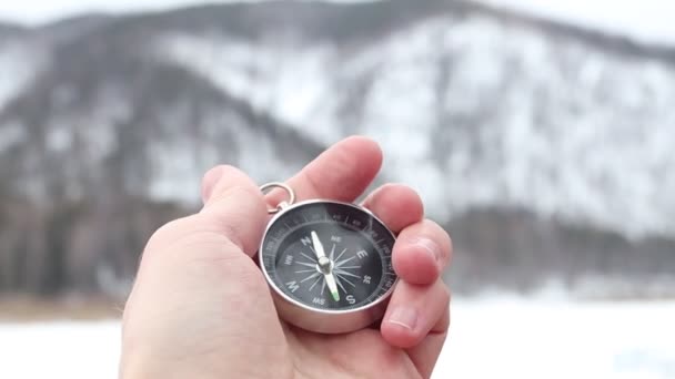 Um turista usa uma bússola. Bússola no fundo de montanhas nevadas. Equipamento para caminhadas — Vídeo de Stock