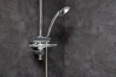 Banyoda duş al. Banyonun içinde. Çatı katı, siyah ve gri fayanslı banyo.