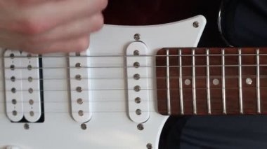 Yakın plan gitar çalıyorum. Elektro gitar çalan bir müzisyen. el gitar çalar
