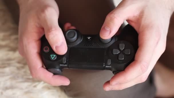 Τα χέρια του παίκτη παίζουν σε παιχνίδι κονσόλας. Ο τύπος πατάει κουμπιά στο χειριστήριο ενός βιντεοπαιχνιδιού. Παίζοντας κονσόλα βιντεοπαιχνιδιών. Χειριστήριο πληκτρολογίου — Αρχείο Βίντεο
