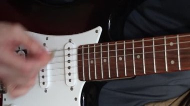 Elektro gitar çalıyor. Erkek eli elektro gitarda oynuyor. Elektro gitar çalan erkeklerin ellerini kapat.