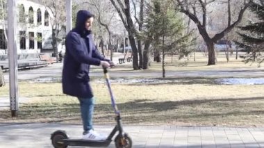 Eleman şehirde elektrikli scooter kullanıyor. Kiralık e-scooter 'da insan bisikleti paylaşımı.