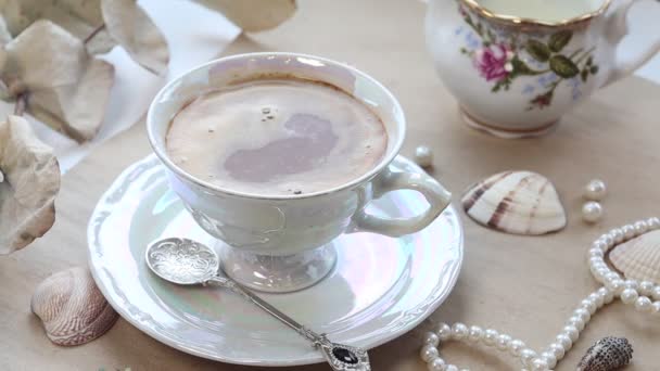 Tejet öntök a kávéba. A tejes kancsó teje egy csésze kávéba ömlik. — Stock videók