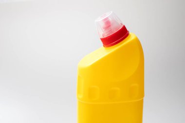 Kırmızı kapaklı sarı plastik kap.