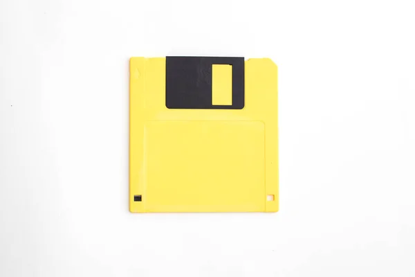 Yellow floppy disk on white background.