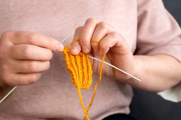 家でオレンジウール糸を編む女性 — ストック写真