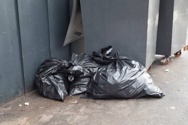 Çöp torbaları çöp tenekesinin yanında. Çöp torbaları çöp tenekelerini dolduruyor. Çantalarla dolu bir çöp kutusu.