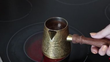 Kadın eli ocağın üstünde Türk kahvesi yapıyor. Céve 'de sade kahve kaynıyor. Türkçe kaynayan sade çiğ kahve