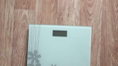 Ağırlık ölçeğinde duran kadın.