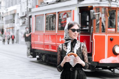 Kızın arkasındaki kırmızı tramvay..