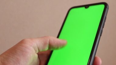Yeşil ekranlı akıllı telefon kullanan bir adam. Mock-up Ekran Kroma Anahtarı akıllı telefon ekranı ile el