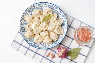 Damalı havlunun üstünde mavi bir tabakta hamur tatlısı..