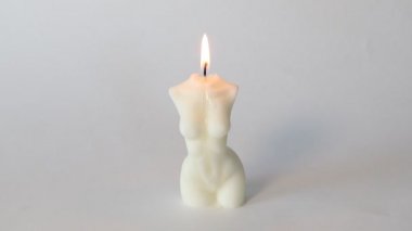 Kadın gövdesi şeklinde mum yanıyor ve sönüyor.