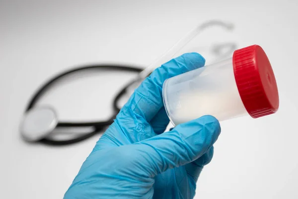 Doktor sperm analizi için plastik bir kavanoz tutuyor. Hastanede tıbbi test. Bankada sperm analizi. Donör Spermi. Erkek sağlığı kavramı.