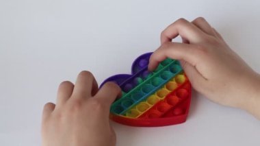 Çocuk oyuncakçılık oynuyor. Çocukların elleri basit bir gamzeli oyuncakla oynuyor.