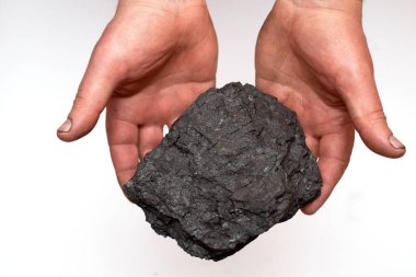 Büyük bir kömür parçasıyla madenci elleri. Kömürlü erkek el.