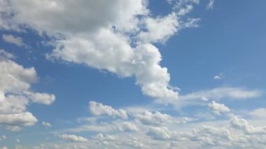 Mavi gökyüzünde süzülen kabarık bulutlar