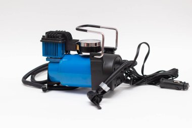 Elektrikli pompa bir araba tekerleği için şişer. Otomatik hava kompresörü beyaz arkaplanda izole edildi.